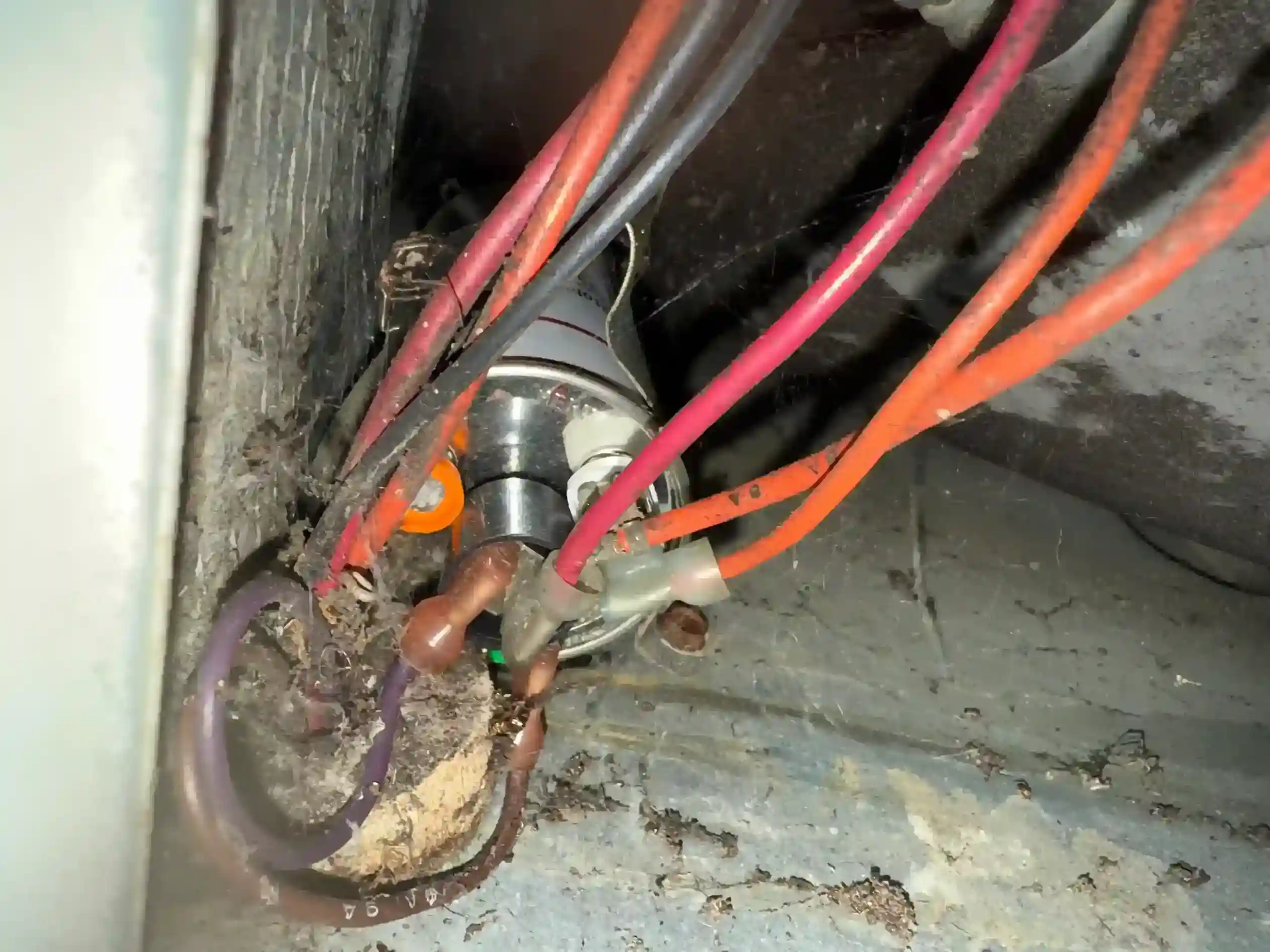 Tangled control wiring and run capacitor inside dirty air handler housing