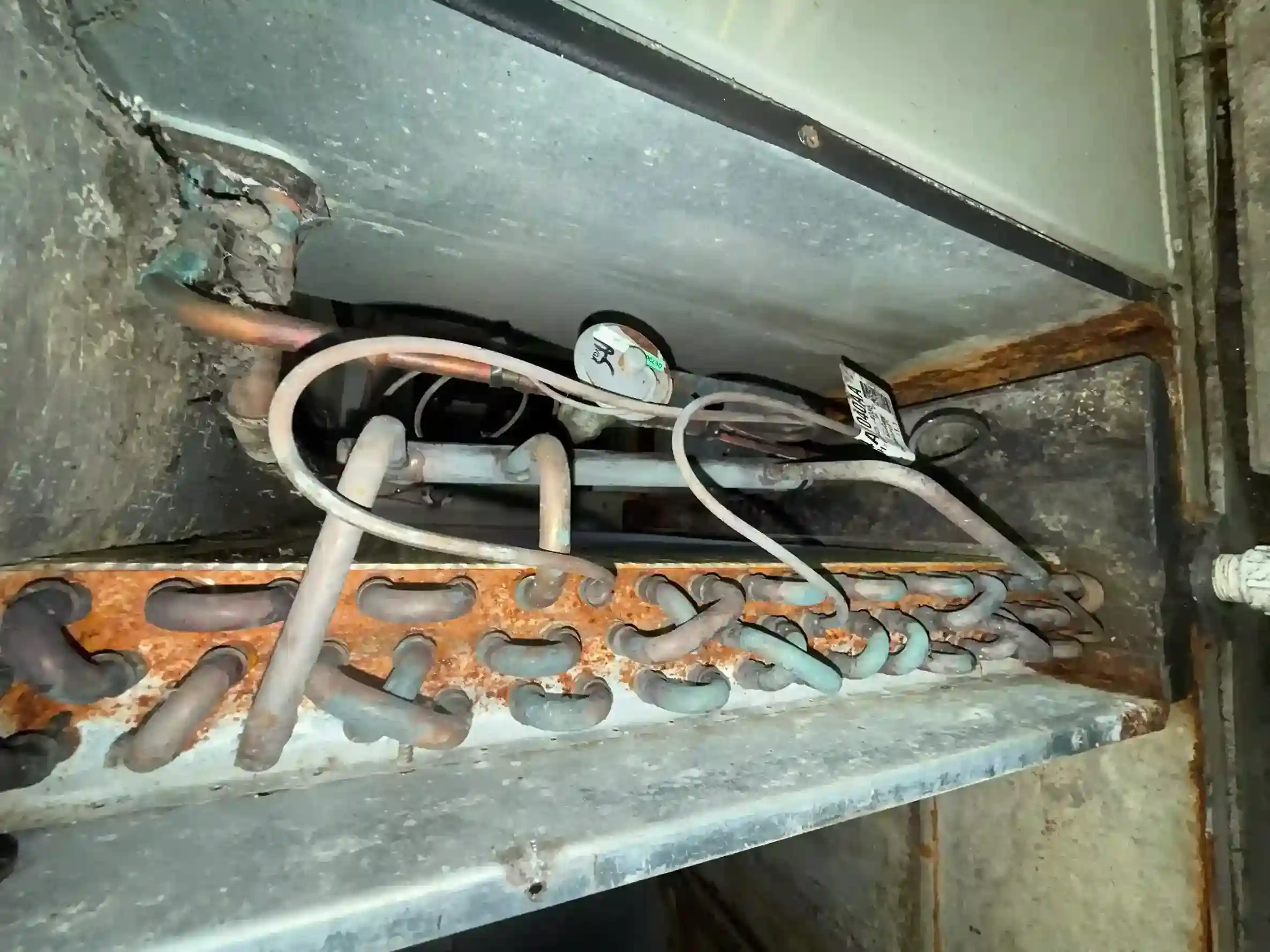 Severely rusted evaporator coil pan, copper U-bend return bends, and TXV expansion valve