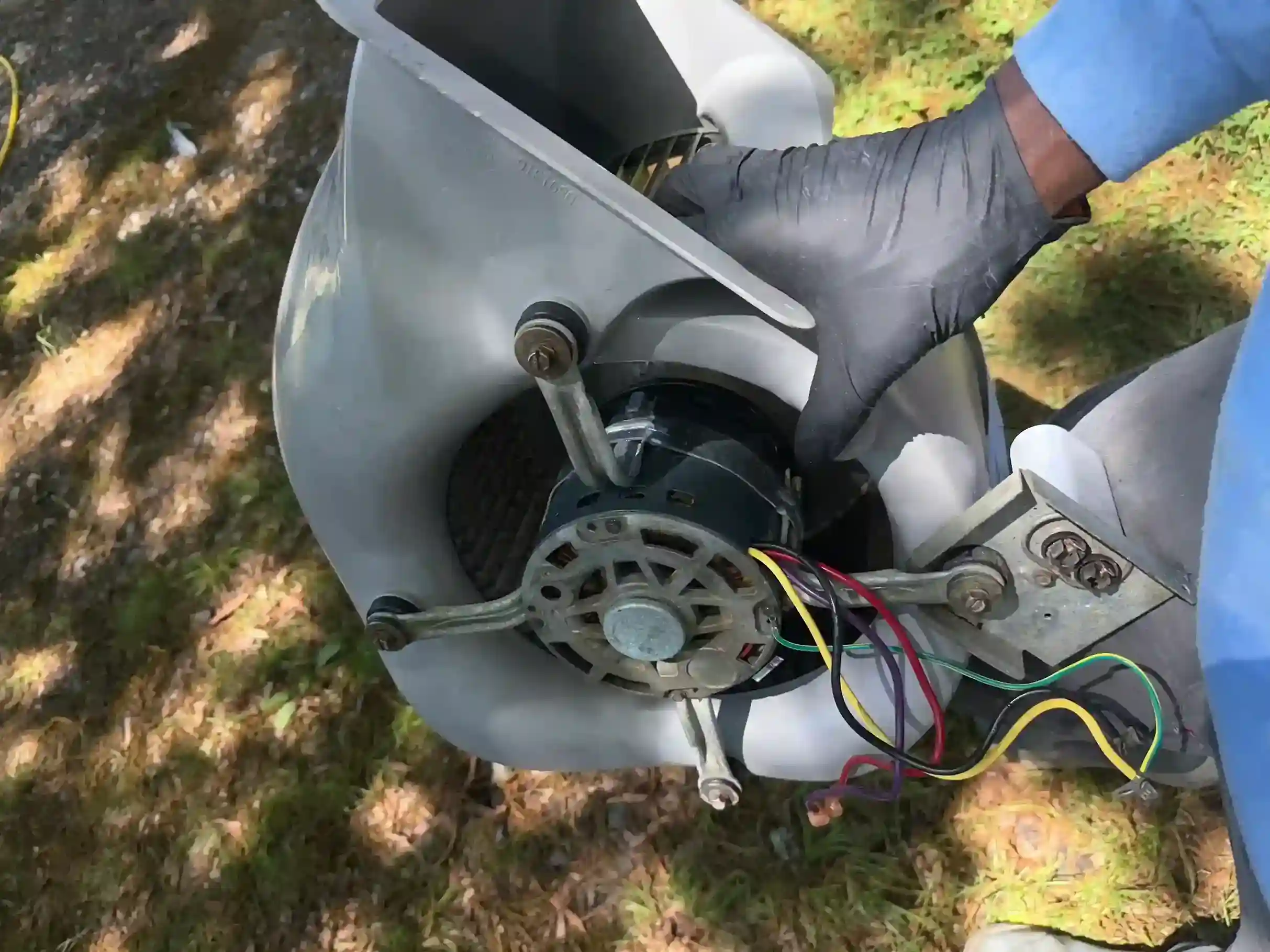 Technician Toy inspecting blower motor lead wires at terminal block connection