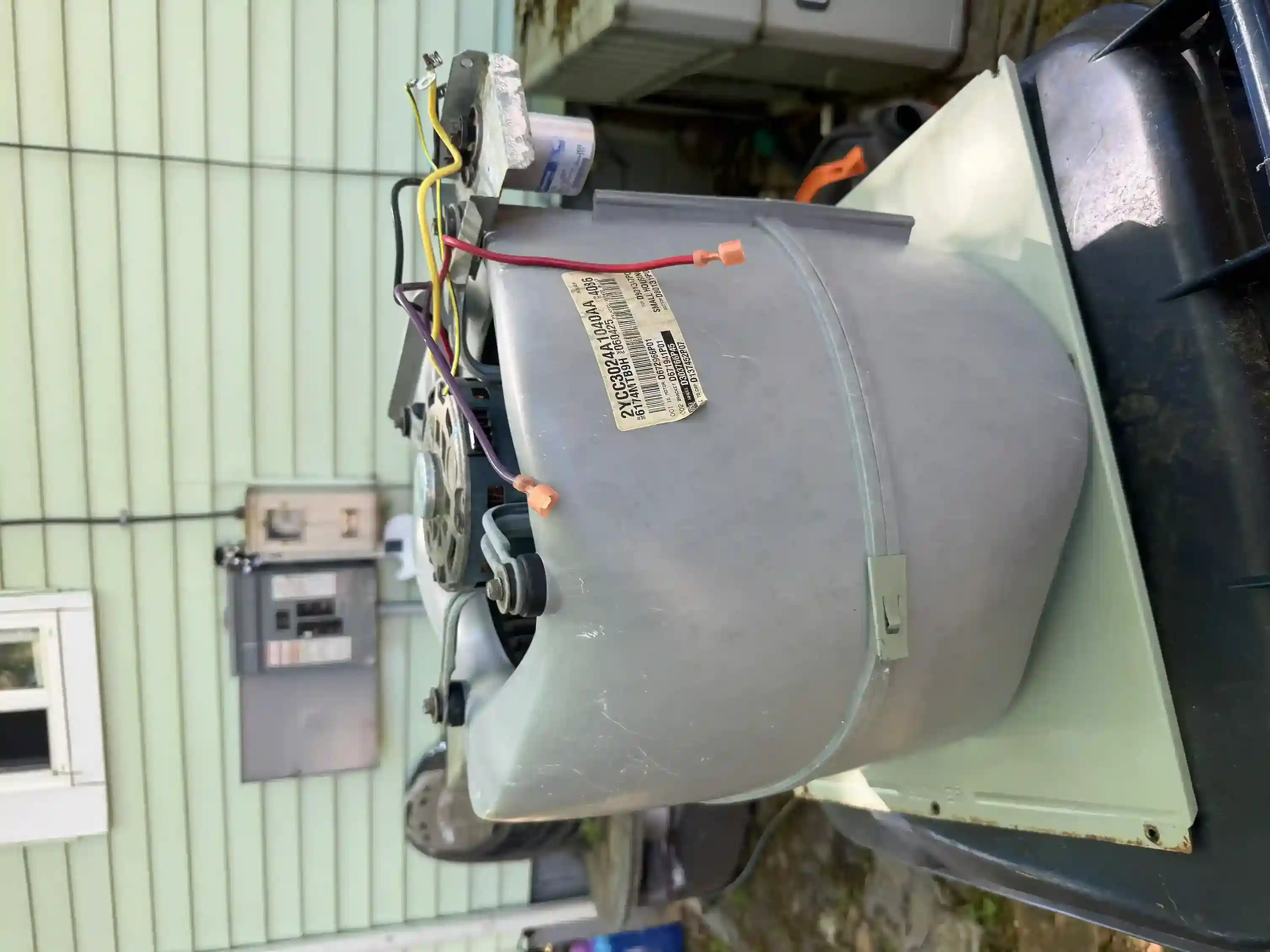 Serviced blower assembly staged at exterior wall ready for reinstallation
