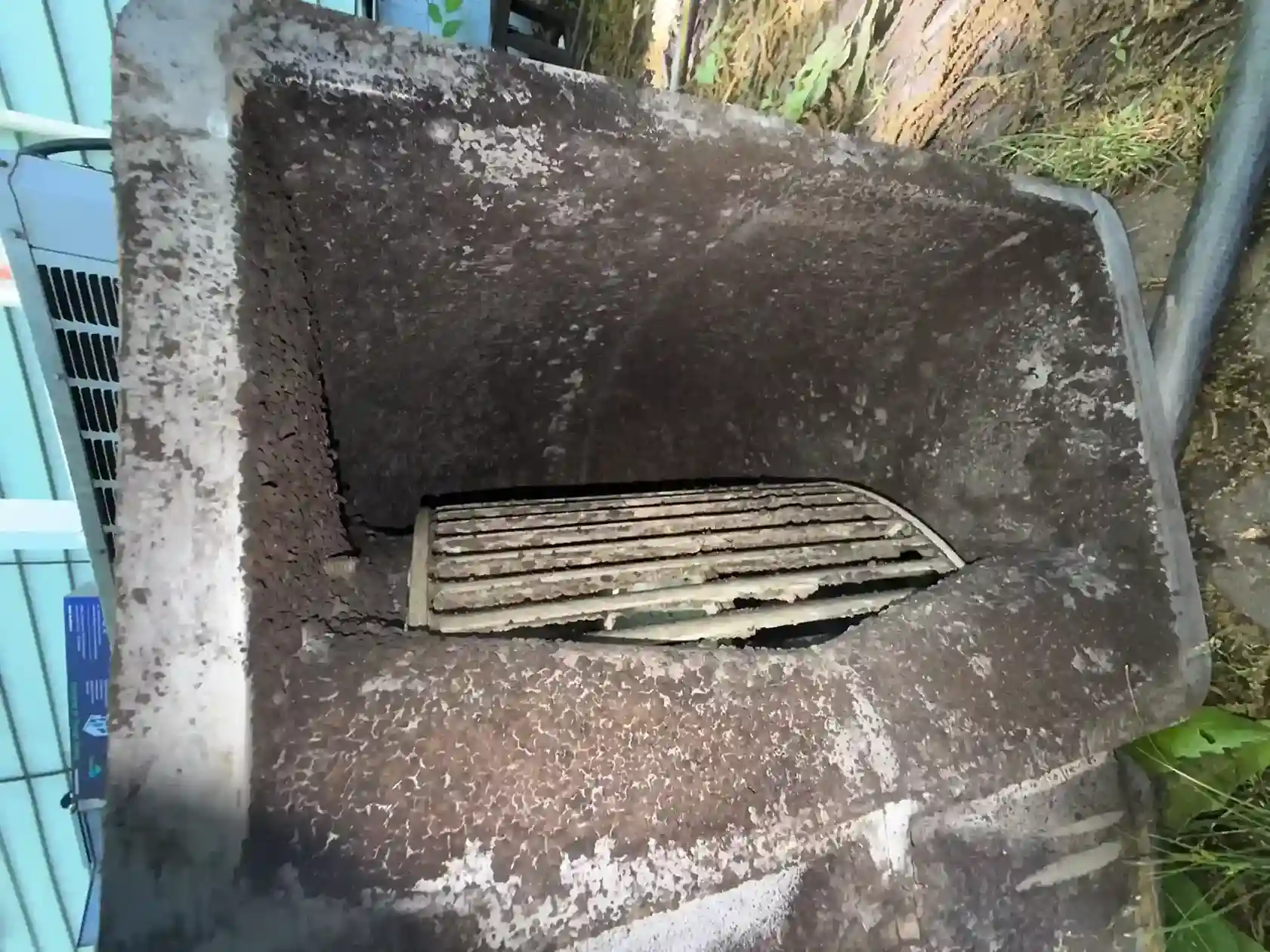 Dust-caked AC unit filter grille prior to cleaning